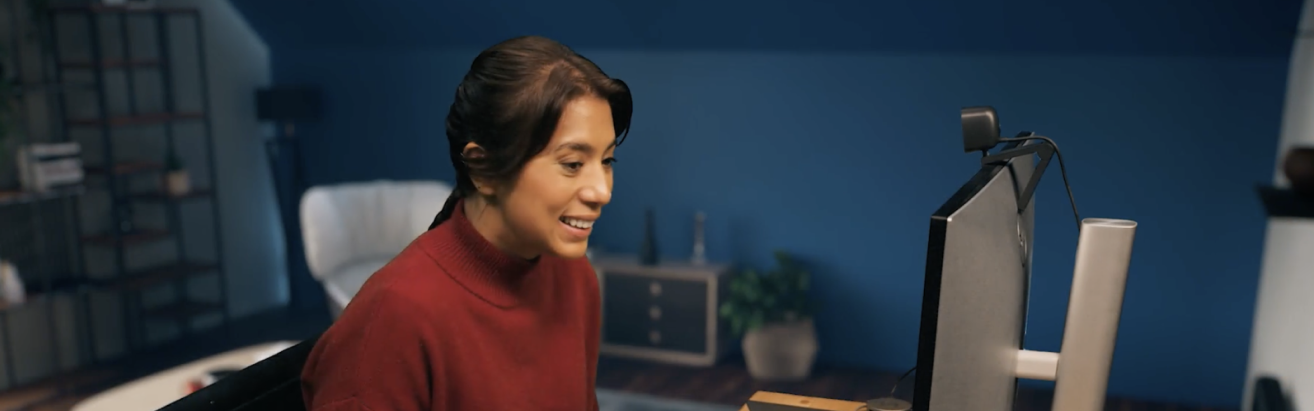 Woman in front of computer using webcam